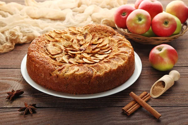 Яблочный торт в тарелке на коричневом столе — стоковое фото