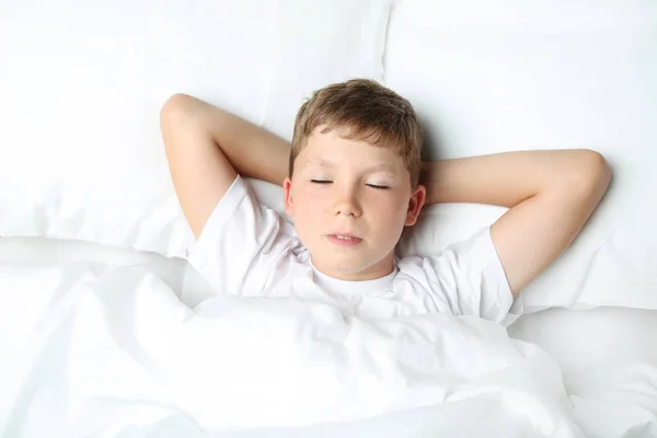 Młody chłopak spanie w łóżku biały — Zdjęcie stockowe