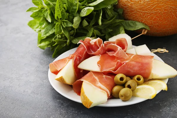 Спелые дыни с хамоном и оливками — стоковое фото