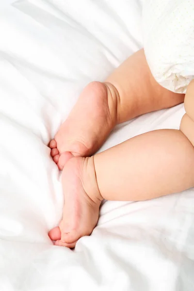 Pés de bebê recém-nascido na cama branca — Fotografia de Stock