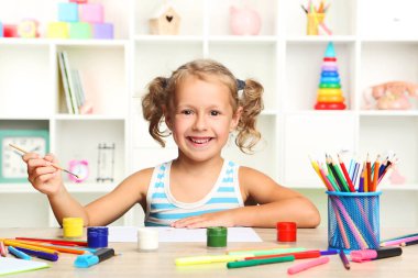 Oturma ve masada çizim küçük kız