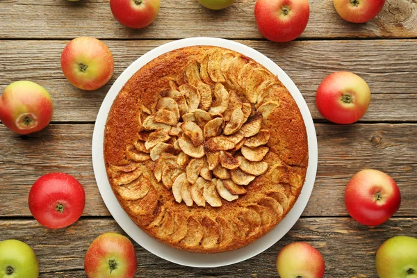 Яблочный торт в тарелке на сером деревянном столе — стоковое фото