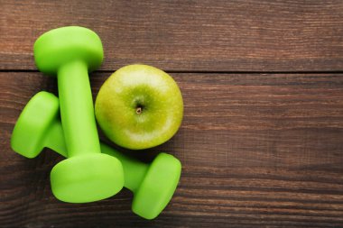 Yeşil elma ve kahverengi ahşap masa üzerinde halter