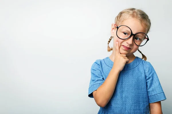 Ritratto di bambina con occhiali su sfondo grigio — Foto Stock