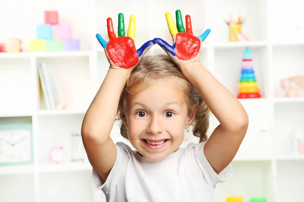 Belle petite fille avec des mains peintes colorées — Photo
