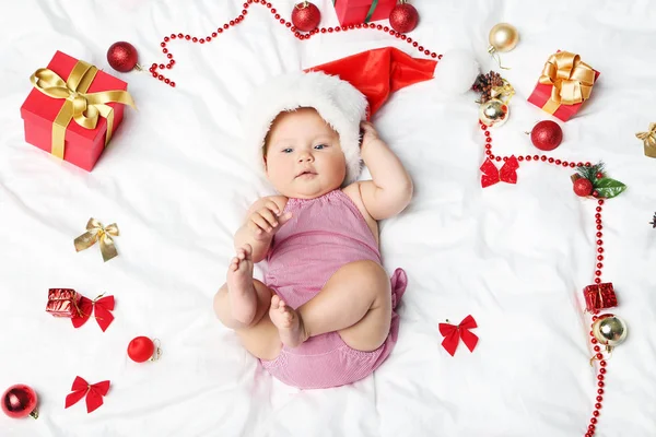 Pequeno bebê recém-nascido com decorações de Natal na cama branca — Fotografia de Stock