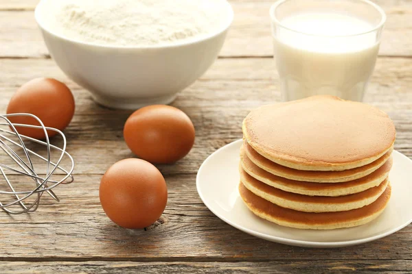 Tasty pancakes in plate with eggs — Stock Photo, Image