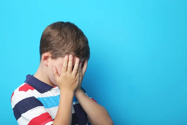 Retrato de menino triste no fundo azul — Fotografia de Stock