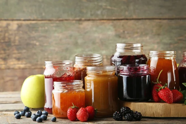 Pots en verre avec différents types de confiture — Photo