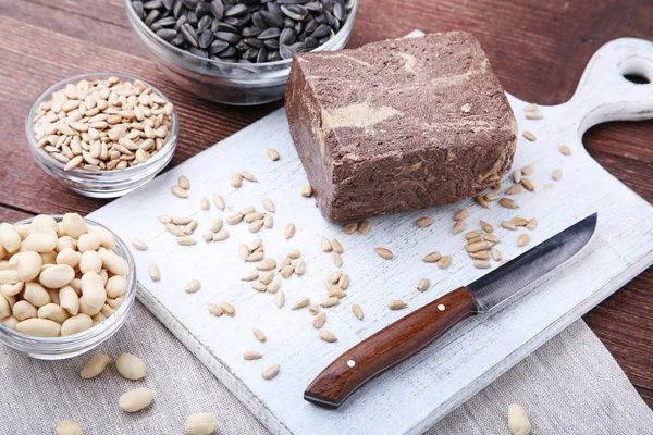 Tasty halva with seeds and knife — Stock Photo, Image