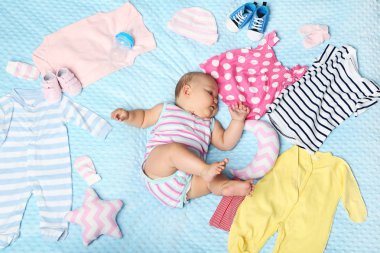 Küçük yeni doğan bebek farklı elbise yatakta