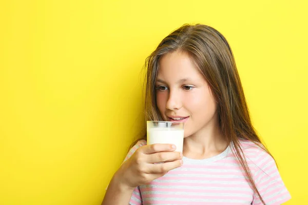 Potret gadis cantik dengan segelas susu di backgrou kuning — Stok Foto