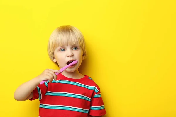 Portrait of little boy with toothbrush on yellow background — Stock Photo, Image