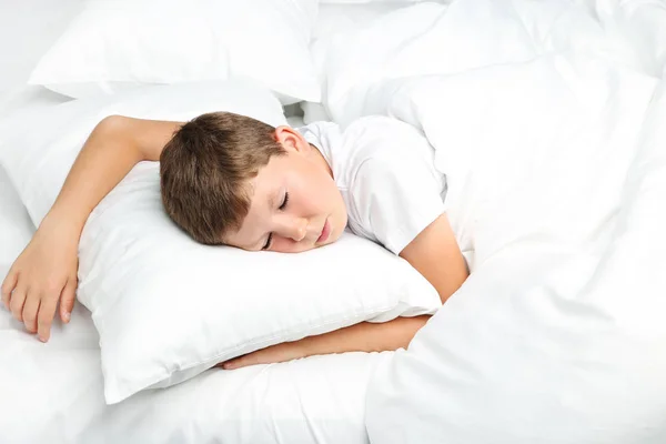 Kleiner Junge schläft in weißem Bett — Stockfoto