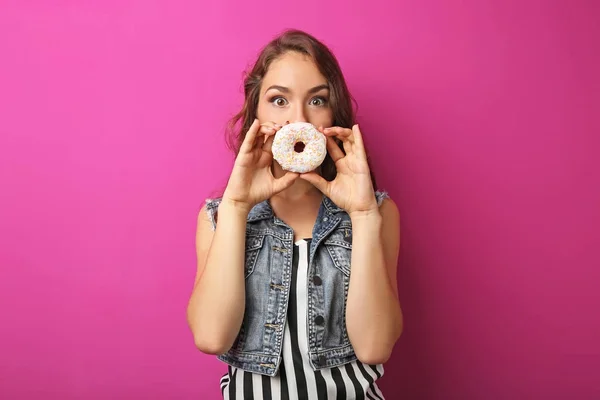 Porträt einer jungen Frau mit süßem Donut auf rosa Hintergrund — Stockfoto