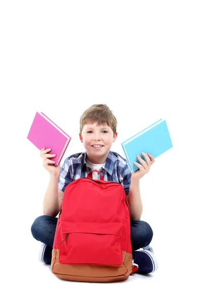 Kleiner Junge mit Büchern und Rucksack auf weißem Hintergrund — Stockfoto