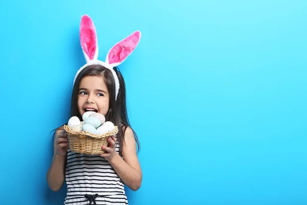 Hermosa niña con orejas de conejo y huevos de Pascua en azul b —  Fotos de Stock