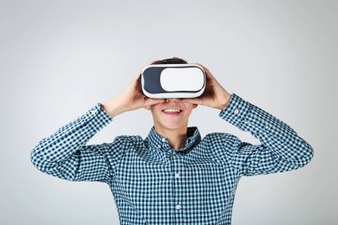 Sanal gerçeklik genç çocuk gri arka plan üzerinde koruyucu gözlük
