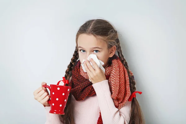 灰色の背景にお茶のカップを持つ病気少女 — ストック写真