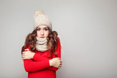 Güzel genç kız şapka ve atkı gri arka plan üzerinde
