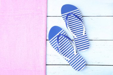 Flip çifti havlu ile ahşap masaya floplar.