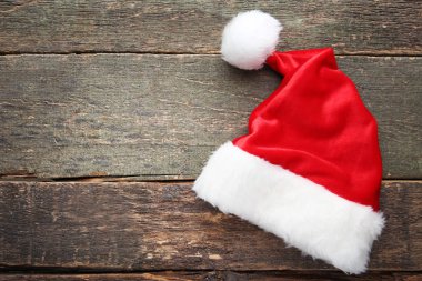 Gri ahşap masa üzerine kırmızı santa şapka