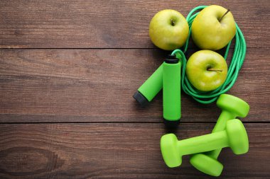 Yeşil elma, ip ve halter ahşap masa üzerinde atlama