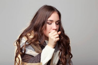 Ekose gri arka plan üzerinde hasta genç kızla