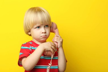 Sarı zemin üzerine telefon ile küçük çocuk portresi