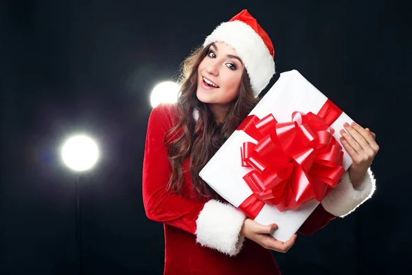 Молодая женщина в красном рождественском костюме держит подарочную коробку — стоковое фото