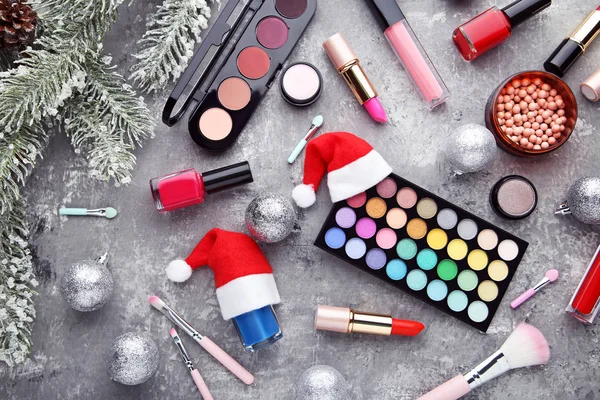 Makeup cosmetics with christmas baubles and fir-tree branch on w — Stock Photo, Image