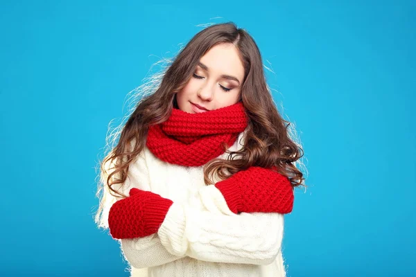 Hermosa joven en suéter, guantes rojos y bufanda en ba azul —  Fotos de Stock