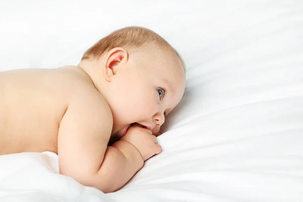 Pequeno bebê recém-nascido na cama branca — Fotografia de Stock