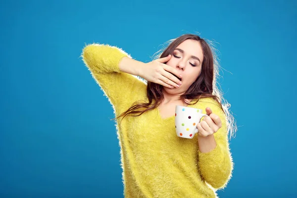 Hermosa joven con taza de té sobre fondo azul —  Fotos de Stock