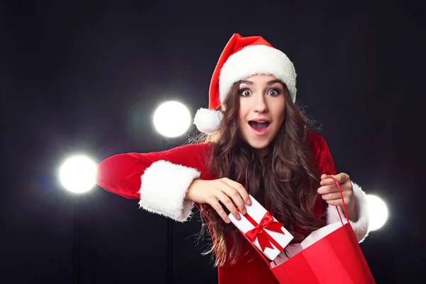 Young woman in red christmas costume holding shopping bags and g — Stock Photo, Image