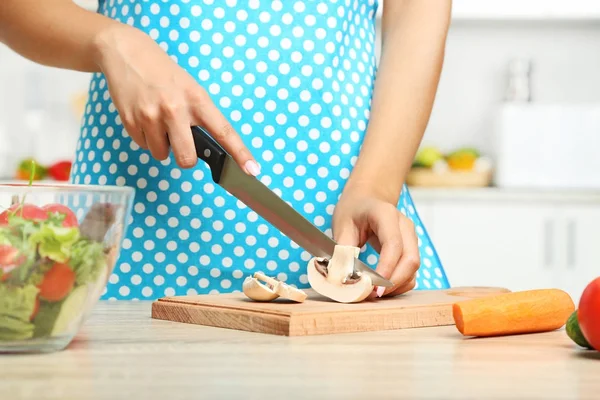 Giovane donna che cucina insalata in cucina — Foto Stock