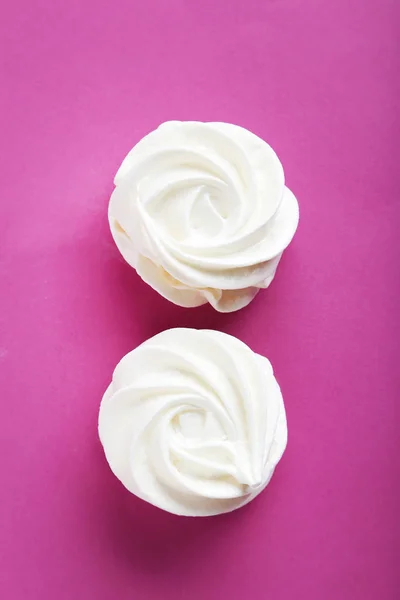 Smakelijke meringue cookies op roze achtergrond — Stockfoto