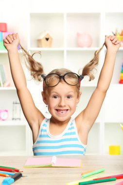 Oturma ve masada çizim küçük kız