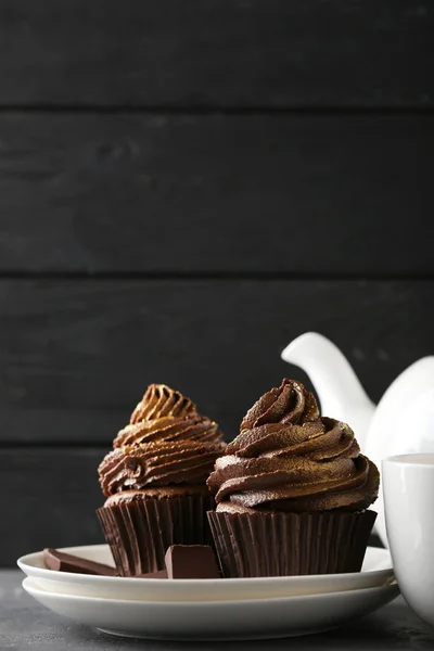 Chocolate cupcakes in plate on wooden table — Stock Photo, Image
