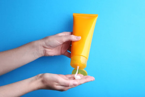 Female hand holding sunscreen cream — Stock Photo, Image