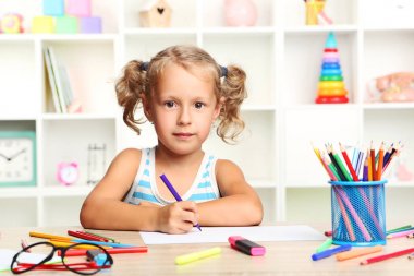 Oturma ve masada çizim küçük kız