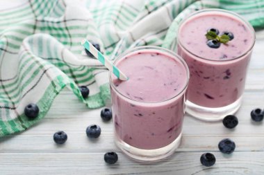 Taze blueberry smoothie gözlüklü Beyaz ahşap masa üzerinde