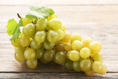 Gri ahşap masa üzerinde yeşil olgun üzüm