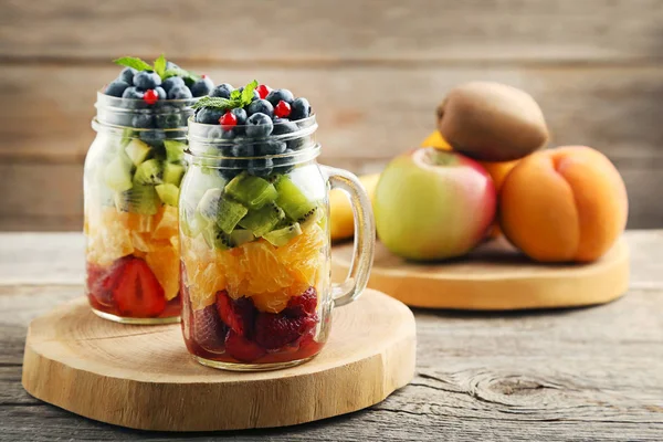 Fresh fruit salad in jars on cutting board