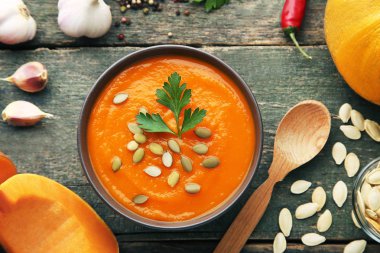 Tohum ve maydanoz ahşap masa üzerinde kase kabak çorbası