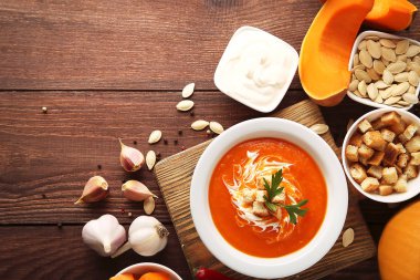 Balkabağı çorbası ekşi krema, Peksimet ve plaka üzerinde ahşap masa maydanoz ile