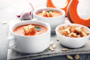 Peksimet ve plaka üzerinde ahşap masa maydanoz ile kabak çorbası