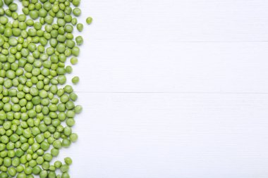 Beyaz ahşap masa üzerinde taze yeşil bezelye