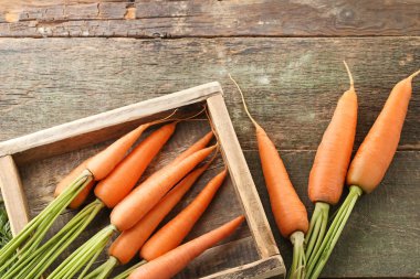 Ahşap masa sandık içinde taze ve olgun havuç
