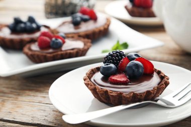 Gri ahşap masa üzerinde çilek ile çikolata tartlets